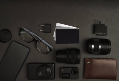 Kameralar, piller, akıllı telefon, yarım ton hedef, gözlük, fiş, lens ve cüzdanın kapağı. Yakın plan. Düz yatıyordu. Boşluğu kopyala.