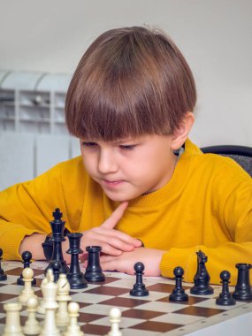 Çocuk bir satranç turnuvasında satranç oynuyor..