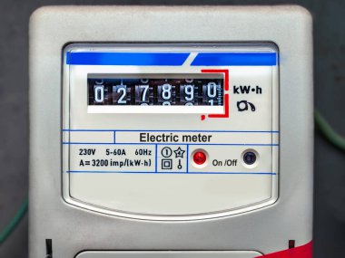 Gri arka planda eski analog elektrik sayacı. Elektrik tüketimi
