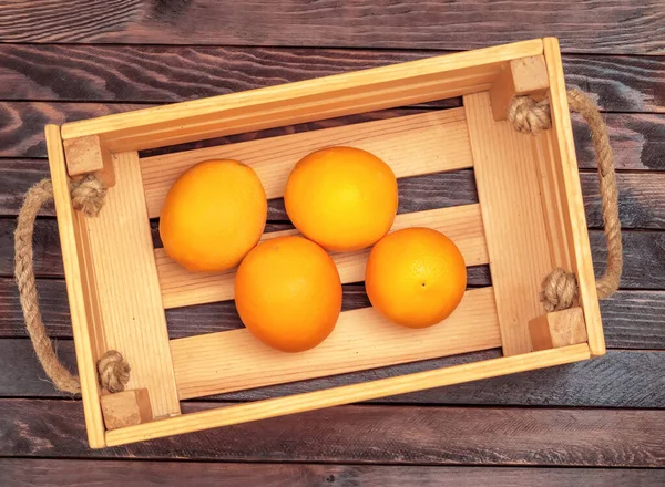 暗い木製の板の背景にオレンジを含む木製の箱 素朴な様式 — ストック写真