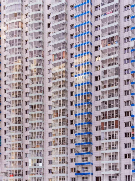 A large number of windows and balconies on building facade. Apartment block. Residential building. Precast apartment building, prefabricated concrete elements. Large panel system-building.