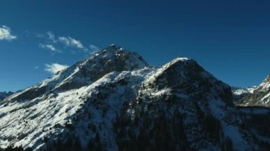 Güneşli bir kış gününde, Molveno Gölü yakınlarındaki Dolomites İtalyan Alplerinde Campanile Basso 'nun 4K hava aracı görüntüsü. Dolimiti di Brenta. Apple Prores 422