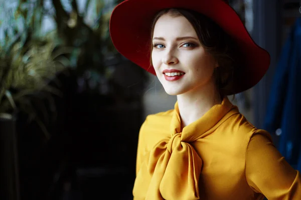 Bir kafede bir kız portresi ile bir fincan kahve ve bir hat.portrait şehvetli genç kızın disket şapka ve yay ile bluz giyiyor. Kafede kahve tutan güzel esmer kadın — Stok fotoğraf