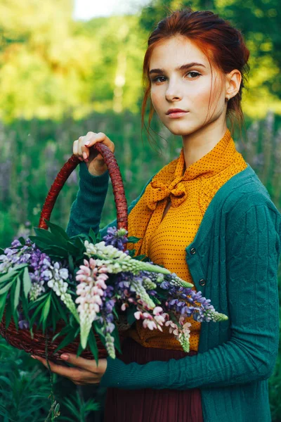 Portret pięknej dziewczyny z brązowymi włosami wśród kwiatów na polu. letnie wakacje z kwiatami. wiejskie — Zdjęcie stockowe