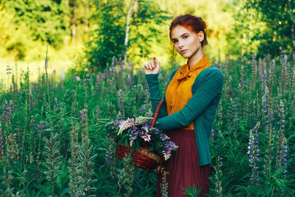 Porträtt av en vacker flicka med brunt hår bland blommorna på fältet. sommarsemester med blommor. landsbygd — Stockfoto