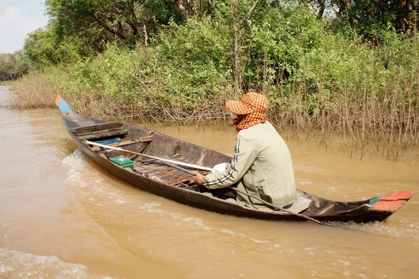 Man floating on a boat on a river of brown — Stock Photo, Image
