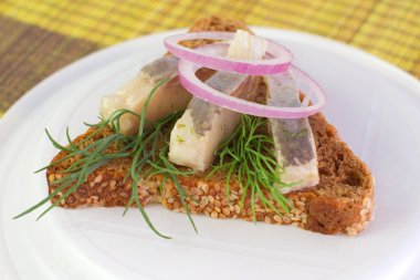 dilimler, ringa balığı, soğan ve dereotu ile bir sandviç