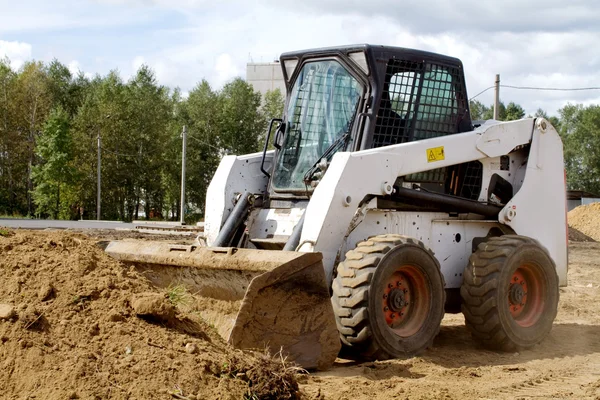 Piccolo bulldozer sta guadagnando terreno nel secchio — Foto Stock