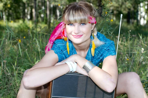 Mooi meisje zit buiten met een bandrecorder — Stockfoto