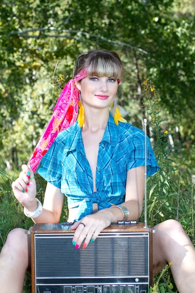 Young beautiful girl sitting outdoors with a tape recorder — Stock Photo, Image