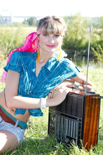 Young beautiful girl sitting outdoors with a tape recorder — Stock Photo, Image