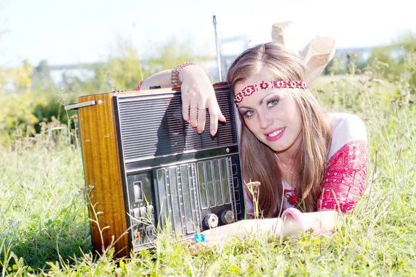 Sexy jonge meisje liggend op het gras en houdt oude tape — Stockfoto