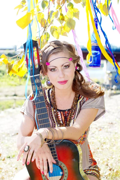 Young beautiful girl sitting with a guitar on the nature Stock Picture