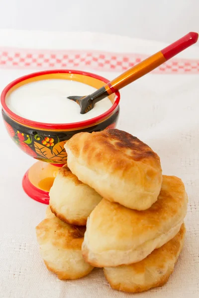 Fried pies with cabbage and sour cream colored saucer