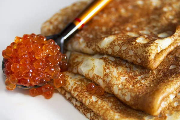 Pancakes and a wooden spoon with red caviar — Stock Photo, Image