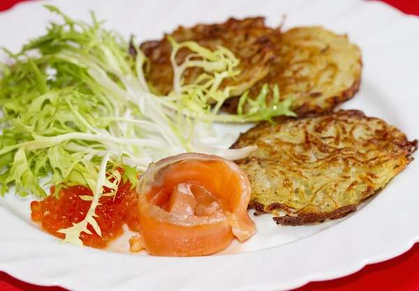 Potato pancakes on a plate with a piece of salmon and red caviar — Stock Photo, Image