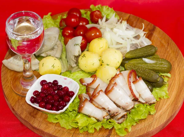Aperitivo rústico com tomate vodka, bacon, picles, cogumelos, batatas e arenque — Fotografia de Stock