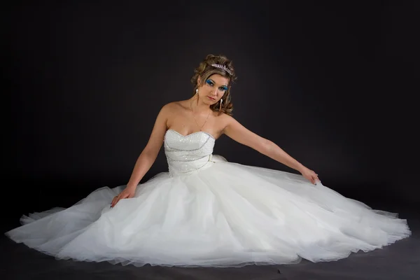 Joven chica sexy en un vestido de novia sobre un fondo oscuro —  Fotos de Stock