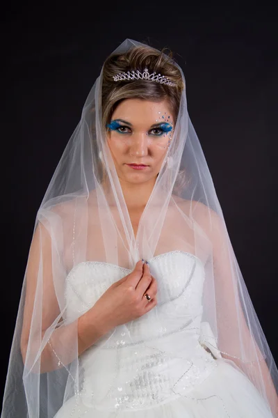 Young sexy girl in a wedding dress on a dark background — Stock Photo, Image