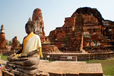 Buddha statue at the temple ruins in the background Ayuthae, Thailand