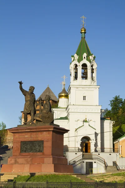 El monumento a los libertadores de Rusia Minin y Pozharsky en el fondo de una iglesia ortodoxa en Nizhny Novgorod —  Fotos de Stock