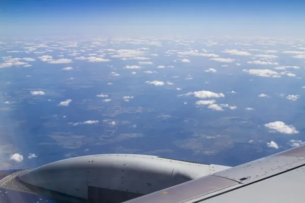 Avião de passageiros asa de uma janela no fundo do céu nublado — Fotografia de Stock