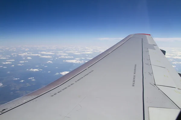Πτέρυγα επιβατικά αεροπλάνα από ένα παράθυρο για το ιστορικό της συννεφιασμένος ουρανός — Φωτογραφία Αρχείου