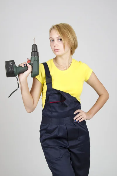 Young beautiful girl in blue overalls and yellow T-shirt — Stock Photo, Image