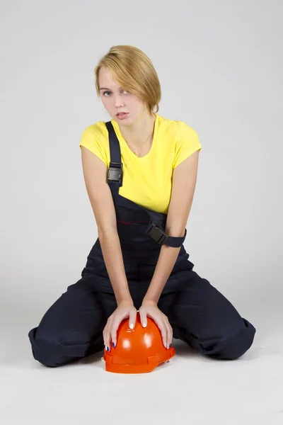 Young sexy girl sitting on the floor with a protective helmet — Stock Photo, Image