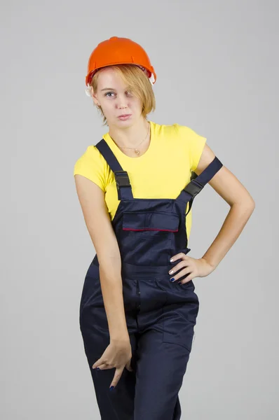 Young attractive girl in the construction overalls — Stock Photo, Image