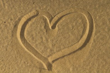 parmağınızla kuma çizilmiş kalp simgesi