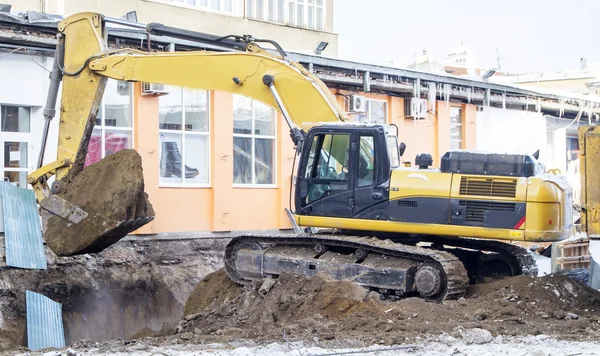 Excavatrice effectue le chargement de la terre dans un camion — Photo