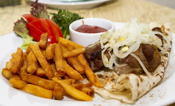 Varkensvlees shish kebab op pita brood met patat en saus — Stockfoto