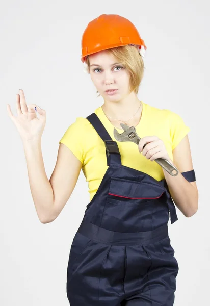 Sexy girl holding a wrench and showing OK sign — Stock Photo, Image