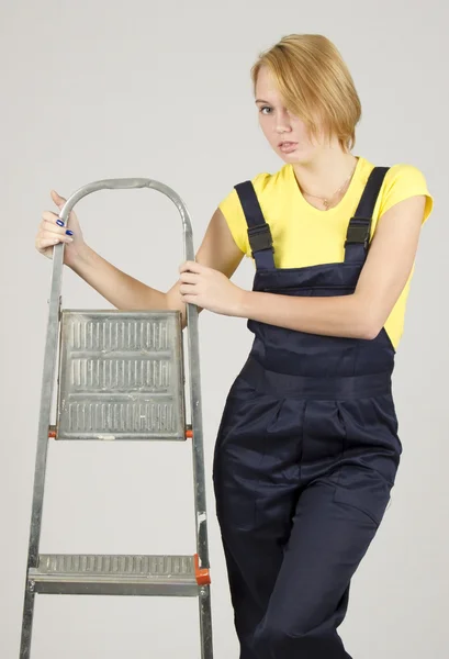Atractiva joven con ropa protectora especial con soportes de escalera — Foto de Stock