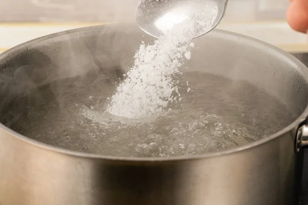 Mit Der Hand Salz Einen Metalltopf Mit Kochendem Wasser Gießen — Stockfoto