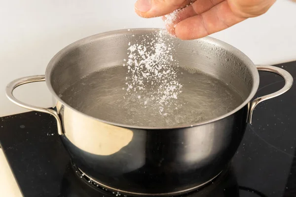 Despeje Sal Uma Panela Metal Água Fervente Com Mão — Fotografia de Stock