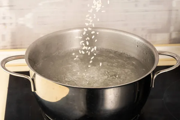 Den Reis Einen Metalltopf Mit Kochendem Wasser Gießen — Stockfoto