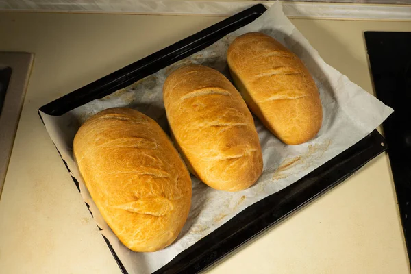 Färska Bakade Bröd Ligga Ett Mörkt Träbord — Stockfoto