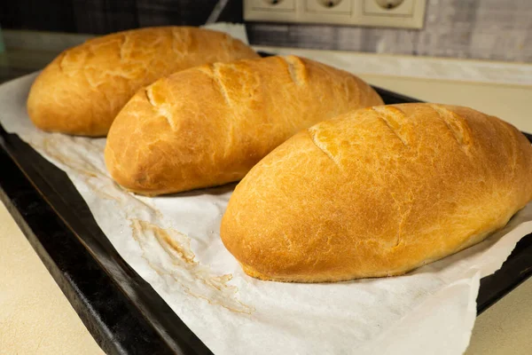 Koyu Ahşap Bir Masanın Üzerinde Taze Ekmek Somunları Yatıyor — Stok fotoğraf