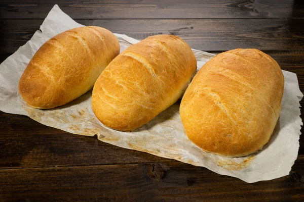 Färska Bakade Bröd Ligga Ett Mörkt Träbord — Stockfoto