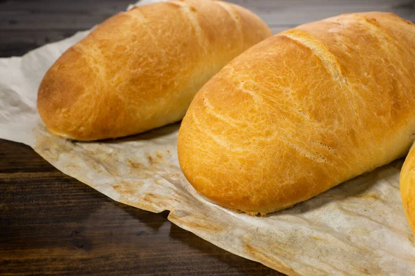 Färska Bakade Bröd Ligga Ett Mörkt Träbord — Stockfoto