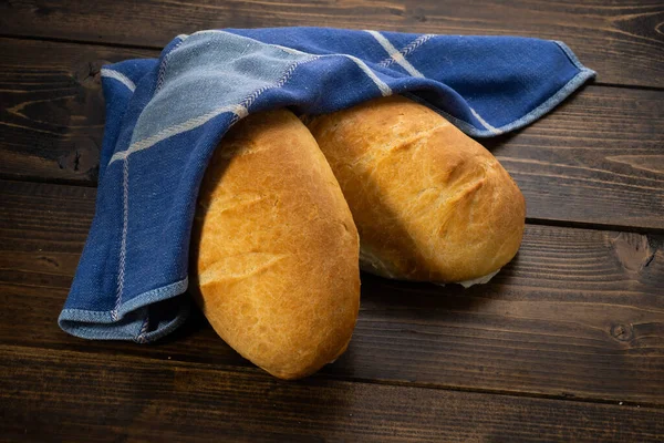 Färska Bakade Bröd Ligga Ett Mörkt Träbord — Stockfoto