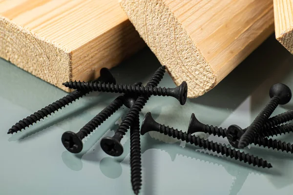 Schwarze Selbstschneidende Schraube Für Holz Neben Einem Stück Holz — Stockfoto
