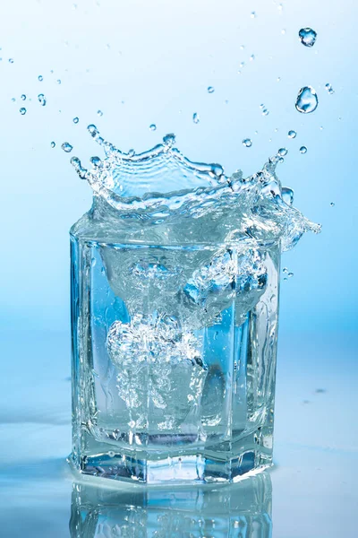 Всплеск Воды Прозрачном Стакане Голубом Фоне Стоковое Фото