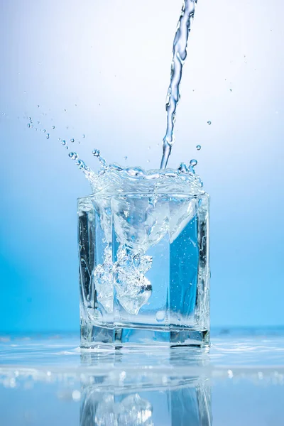 Всплеск Воды Прозрачном Стакане Голубом Фоне Стоковое Изображение