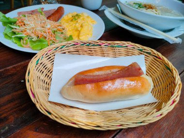 A breakfast set include a Vietnamese sandwich,  the thick rice noodle soup with Vietnamese sausage and scrambled eggs with salad. Focus at Vietnamese sandwich.