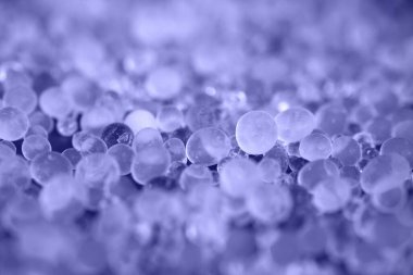 Yakın çekim - mavi arka planda silis jeli yığını, endüstriyel nemlendirici olarak kullanılan Desiccant. Desiccant Silica Jeli (Nem Emici) Arka plan. 2022 'nin Rengi - Çok Peri.