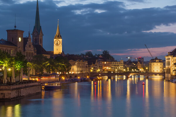 Evening. View of Limmat river with Fraumunster and st. Peter church, Zurich