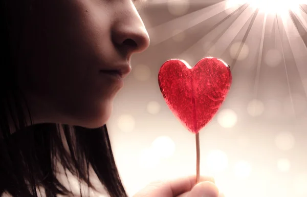 Beautiful girl with red heart on bokeh lights background — Stock Photo, Image